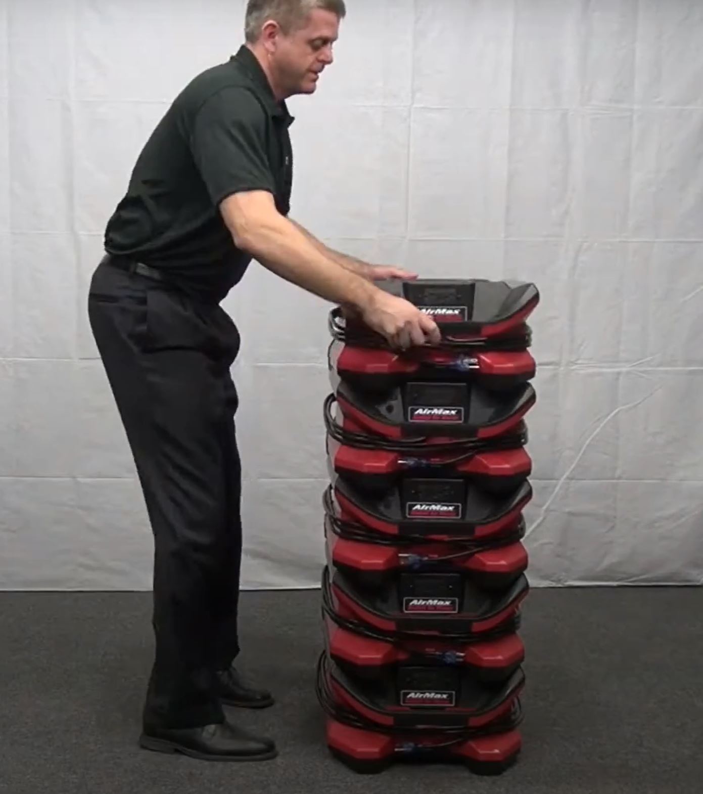 shows a man stacking red Phoenix AirMAX Radial Air Movers
