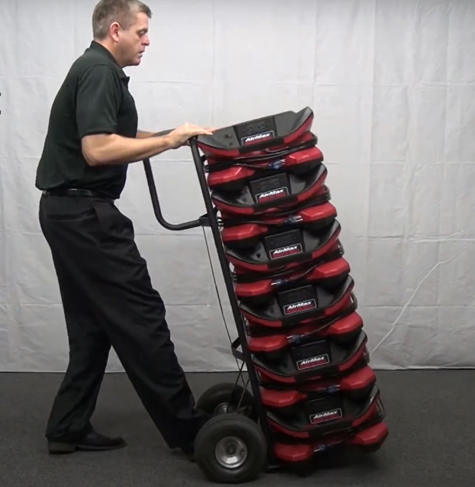 shows a man using a dolly to transport Phoenix AirMAX Radial Air Movers