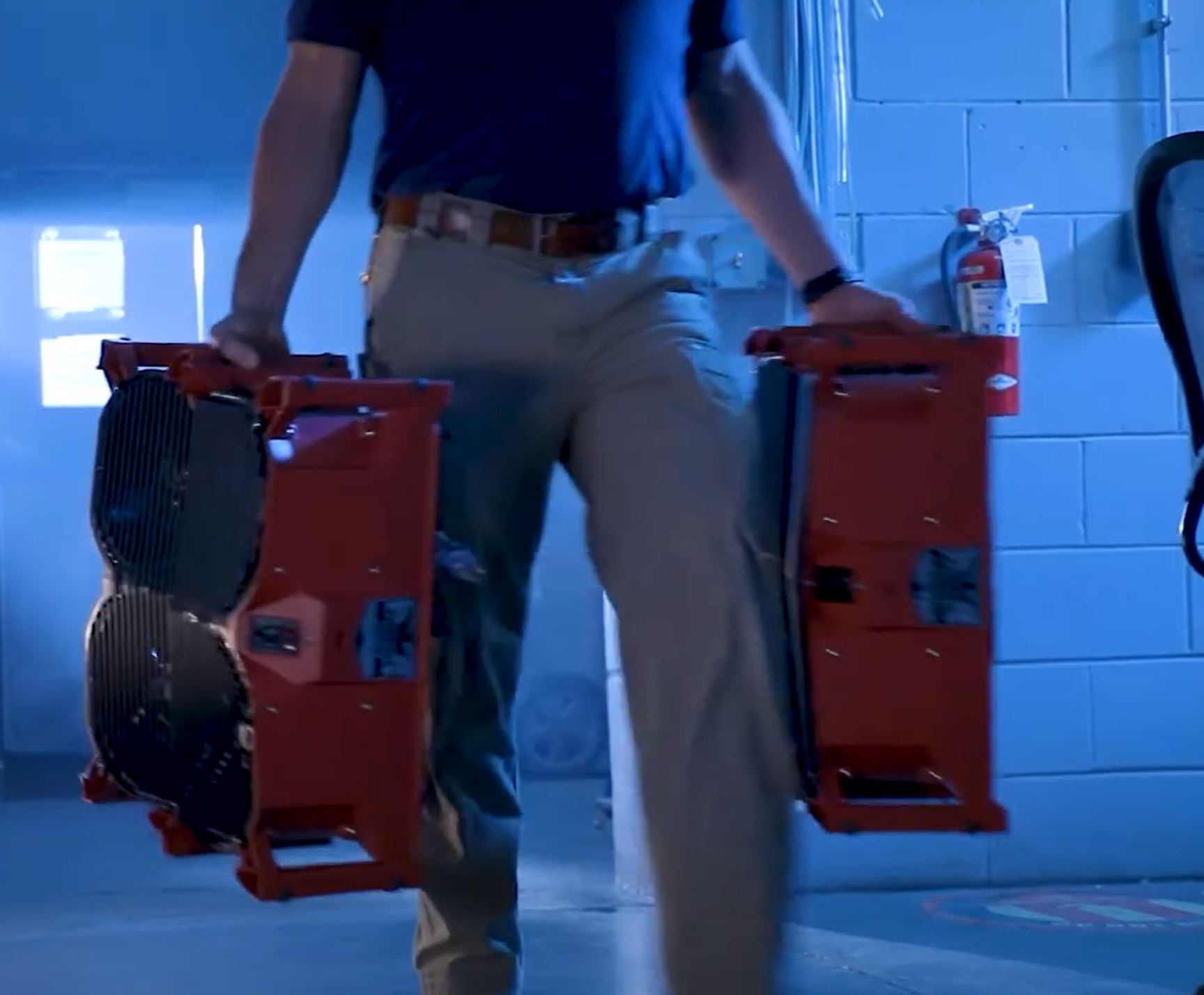 man carrying 2 phoenix focus ii dual axial air mover in each hand
