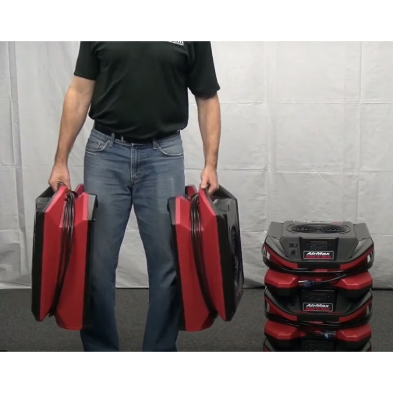 phoenix airmax radial air mover in red being carried by the handle by a man and 2 units are in the background stacked up